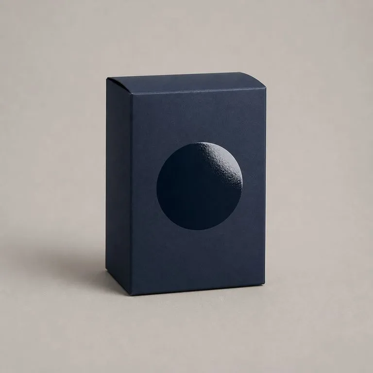 A matte carton with one raised glossy shape on the front panel catching the light