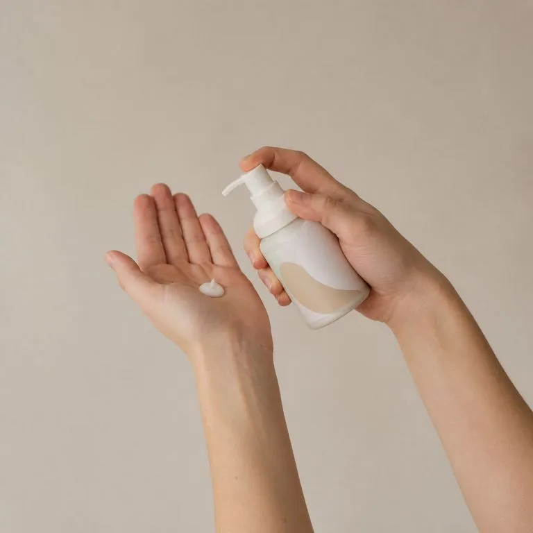 A pump bottle held mid-use rather than presented to camera