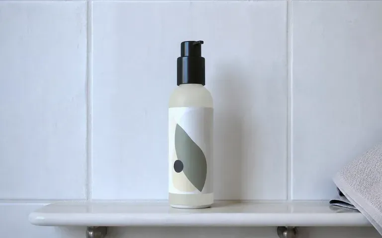 A skincare bottle on a bathroom shelf in morning light