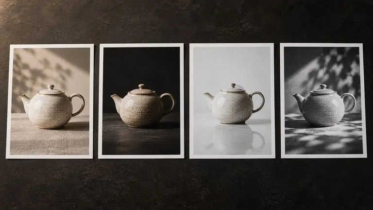 Concept illustration: Four distinct unbranded printed contact sheets laid in a neat row on a dark review table, different visual treatments around the same ceramic teapot, no readable headings or fake UI