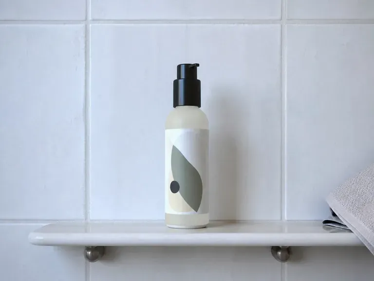A skincare bottle on a bathroom shelf in morning light