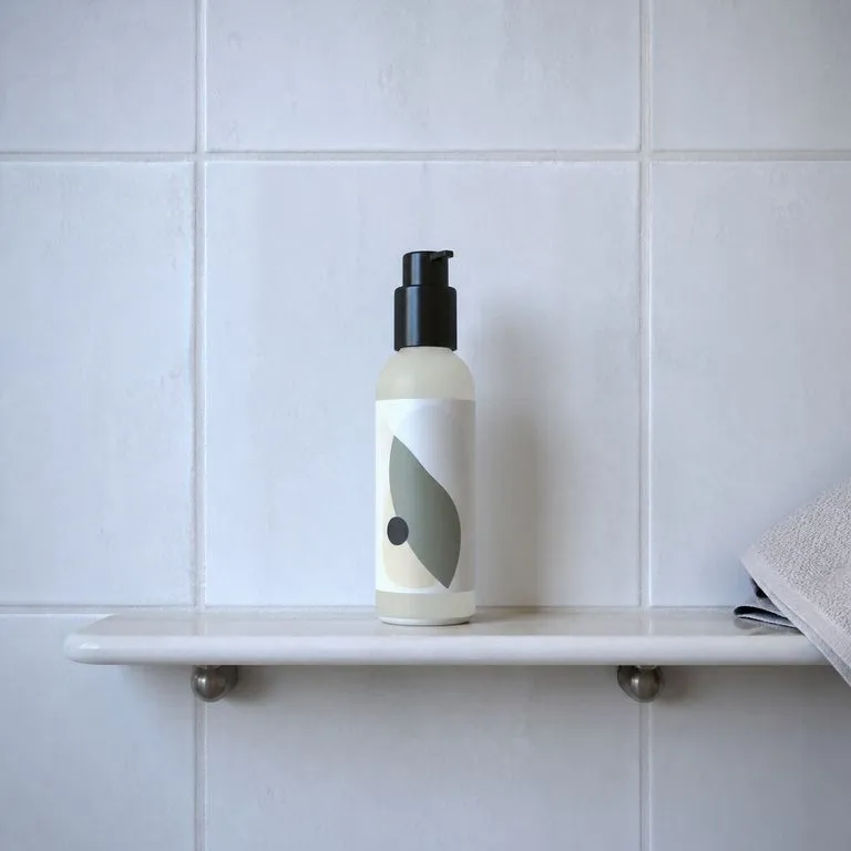 A skincare bottle standing on a bathroom shelf in morning light